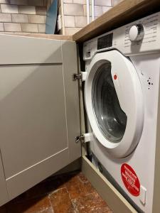 uma máquina de lavar e secar roupa numa cozinha com um balcão em The Cottage, Watergate, Sleaford em Lincolnshire