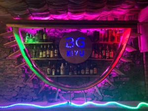 a bar with a neon sign on a shelf at Kivu Beach Garden in Gisenyi