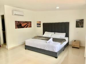 a bedroom with a large bed with a black headboard at Hotel Santorini in San Gil