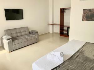 a living room with a couch and a television at Hotel Santorini in San Gil