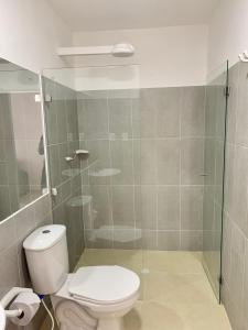 a bathroom with a toilet and a glass shower at Hotel Santorini in San Gil