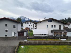 un groupe de bâtiments blancs avec des montagnes en arrière-plan dans l'établissement Ferienwohnung Scharf, à Reutte