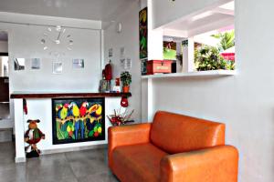 an orange chair in a living room with a fireplace at Hotel & Restaurante Siami in Leticia