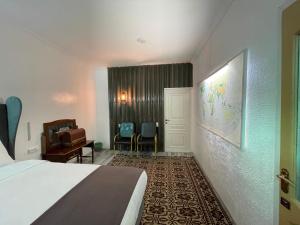 a hotel room with a bed and a desk and a chair at Duet Hostel & Hotel in Karakol