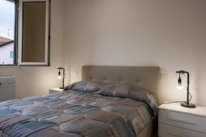 Un dormitorio con una cama con dos mesitas de noche y dos lámparas. en Santo Stefano di Magra Modern Apartments, en Santo Stefano di Magra