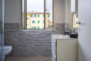 Un baño con inodoro y ventana. en Santo Stefano di Magra Modern Apartments, en Santo Stefano di Magra