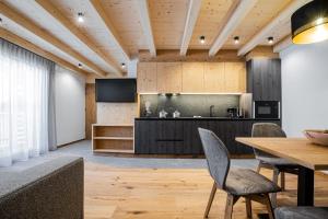 a dining room with a table and a television at Bio Lüch Ruances in San Cassiano