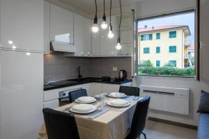 Una cocina y un comedor con mesa y sillas. en Santo Stefano di Magra Modern Apartments, en Santo Stefano di Magra