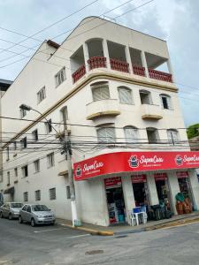 a building on a street with cars parked in front of it at Elite Economy Hotel in Pará de Minas