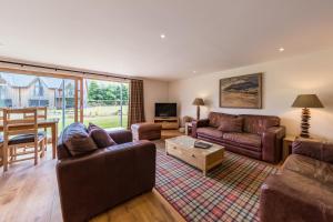 a living room with two couches and a table at Mains of Taymouth Country Estate 5* Gallops Apartments in Kenmore