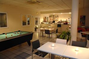 un restaurante con mesa de billar, mesas y sillas en Hotel Bulevard, en Benicàssim
