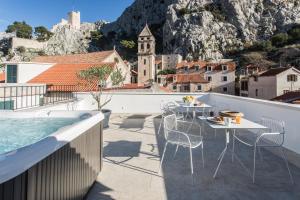 a balcony with tables and chairs and a swimming pool at Stone House Franco in Omiš