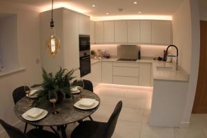 a kitchen and dining room with a table and chairs at Hideaway in Great Urswick