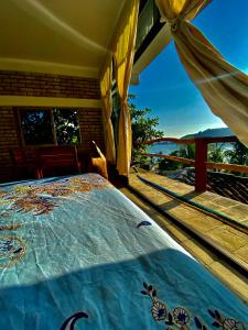 a bedroom with a bed with a view of the ocean at Casa Gundi y Tomas in Puerto Ángel