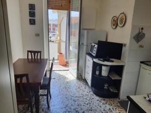 een keuken met een tafel en een televisie en een eetkamer bij Appartamento La Fortezza in Livorno