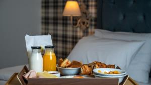 Una bandeja de comida con leche y bebidas sobre una cama. en Brettania Hotel, en Ioannina 31 fotos más