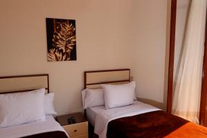 duas camas num pequeno quarto com dois ermottermott em Ismailia House Inn no Cairo