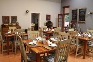 a dining room with wooden tables and chairs at Del Roza Guest House in Middelburg