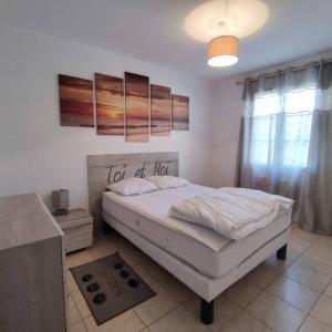 a bedroom with a white bed and a window at Avec piscine à Dolus in Dolus-d'Oléron +26 photos