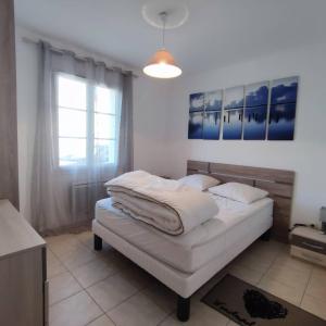 a bedroom with a bed with white sheets and a window at Maison moderne au centre d'Oléron in Dolus d'Oléron +27 photos