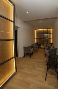 una sala de espera con sillas y mesas en un edificio en Brettania Hotel, en Ioannina