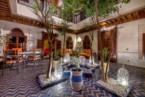 una stanza con diversi alberi e sedie in vaso di Maïpa Boutique Riad a Marrakech