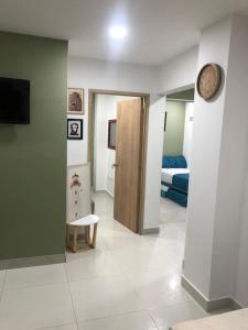 a hallway with a room with a bed and a clock at Hermoso Apartamento de 2 alcobas in Cartagena de Indias