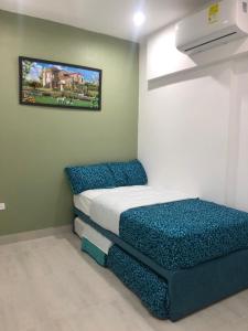 卡塔赫納的住宿－Hermoso Apartamento de 2 alcobas，一间小卧室,配有一张床和墙上的照片