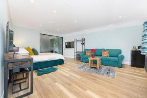 1 dormitorio con cama, sofá y TV en Westleigh, en Ashtead