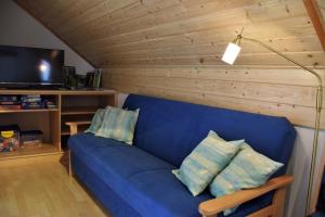 a blue couch with pillows in a living room at Bio-Ferienhof Hochbrandt in Spital am Pyhrn