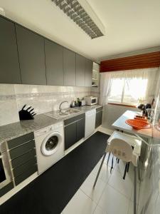 eine Küche mit einer Waschmaschine und einem Waschbecken in der Unterkunft House in beach- Oporto in Arcozelo