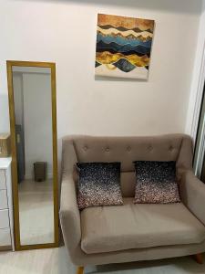 a living room with a couch and a mirror at Unit 1537 Bahamas tower Azure Urban Resort Residence Paranaque City in Bacoor