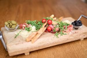 a wooden cutting board with different types of vegetables on it at Alpendorf Hotel Stern in Sankt Johann im Pongau +70 photos