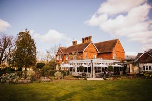 a large red brick house with a lawn at The Farmhouse at Redcoats in Stevenage