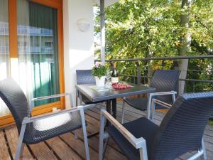 a table and chairs on a balcony with a bottle of wine at Kaiservillen Heringsdorf - Ferienwohnung mit 1 Schlafzimmer und Balkon D112 in Heringsdorf