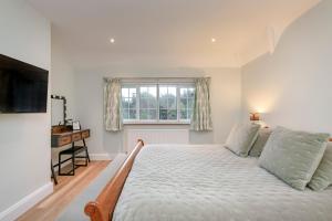 1 dormitorio con cama y ventana en Westleigh en Ashtead