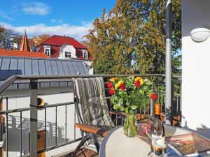 une table avec un vase de fleurs sur un balcon dans l'établissement Kaiservillen Heringsdorf - Ferienwohnung mit 1 Schlafzimmer und Balkon D221, à Heringsdorf