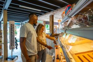 a man and a woman looking at a counter in a store at Comfort Rooms by EuroParcs Het Amsterdamse Bos in Amstelveen