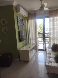ein Wohnzimmer mit einem Sofa und einem Flachbild-TV in der Unterkunft APARTAMENTO RIVIERA DE SÃO LOURENÇO in Riviera de São Lourenço
