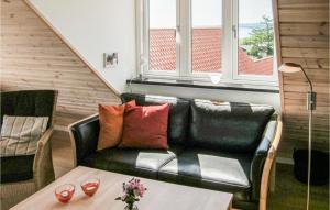 a living room with a black couch and a table at Beautiful Apartment In Gudhjem With 2 Bedrooms in Gudhjem