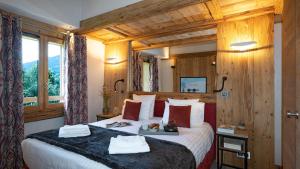 Habitación de hotel con cama grande y paredes de madera. en Residence Alexane en Samoëns