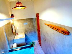 a bathroom with a sink and a surfboard on the wall at Odoyá Corumbau in Corumbau +34 photos