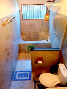 a bathroom with a toilet and a bath tub at Odoyá Corumbau in Corumbau