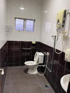 uma casa de banho com um WC, um lavatório e uma janela em Coconut House em Malaca