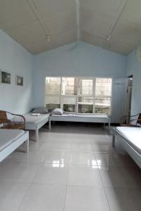 a large room with two beds and two windows at Benara Shariah Homestay in Yogyakarta