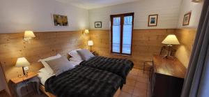 a bedroom with a bed and a desk and two lamps at Short stay & Weekly rental - La Grave in La Grave