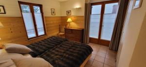 a bedroom with a bed and a dresser and windows at Short stay & Weekly rental - La Grave in La Grave