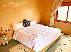 un grande letto bianco in una camera da letto con finestra di Chateau Imilchil a Imilchil