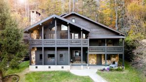 Outland Chalet & Suites Great Smoky Mountains في Whittier: منزل كبير في وسط غابة