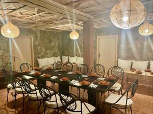 een eetkamer met een tafel, stoelen en verlichting bij Chateau Imilchil in Imilchil